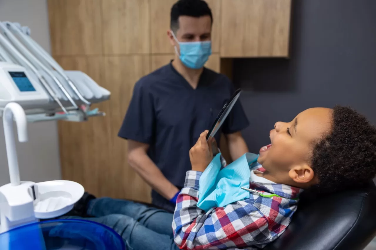 Child relaxed in a dental chair with a tablet