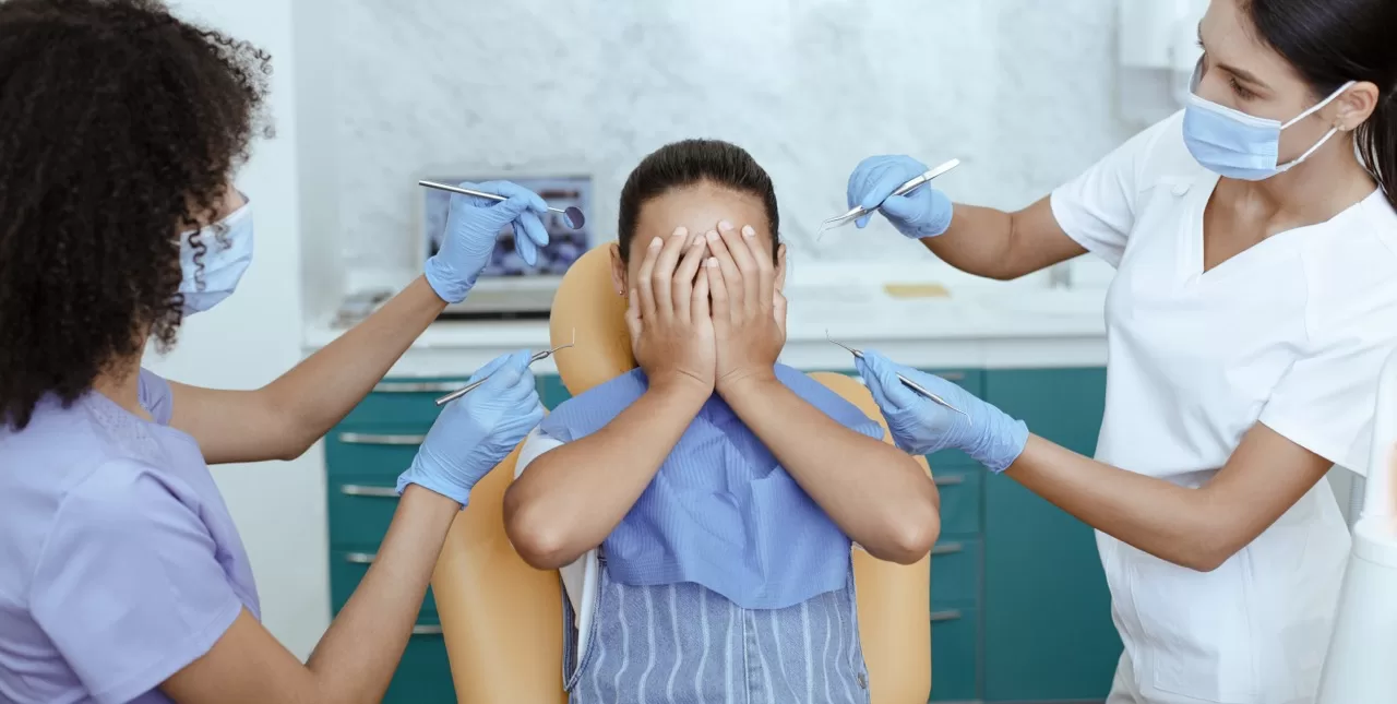 Child showing dental anxiety at dentist office