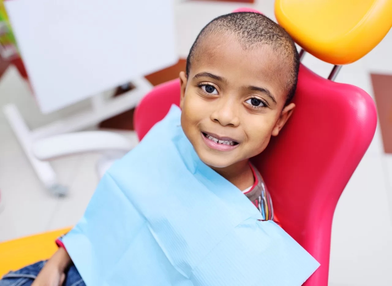 Smiling child in dental chair before a dental visit