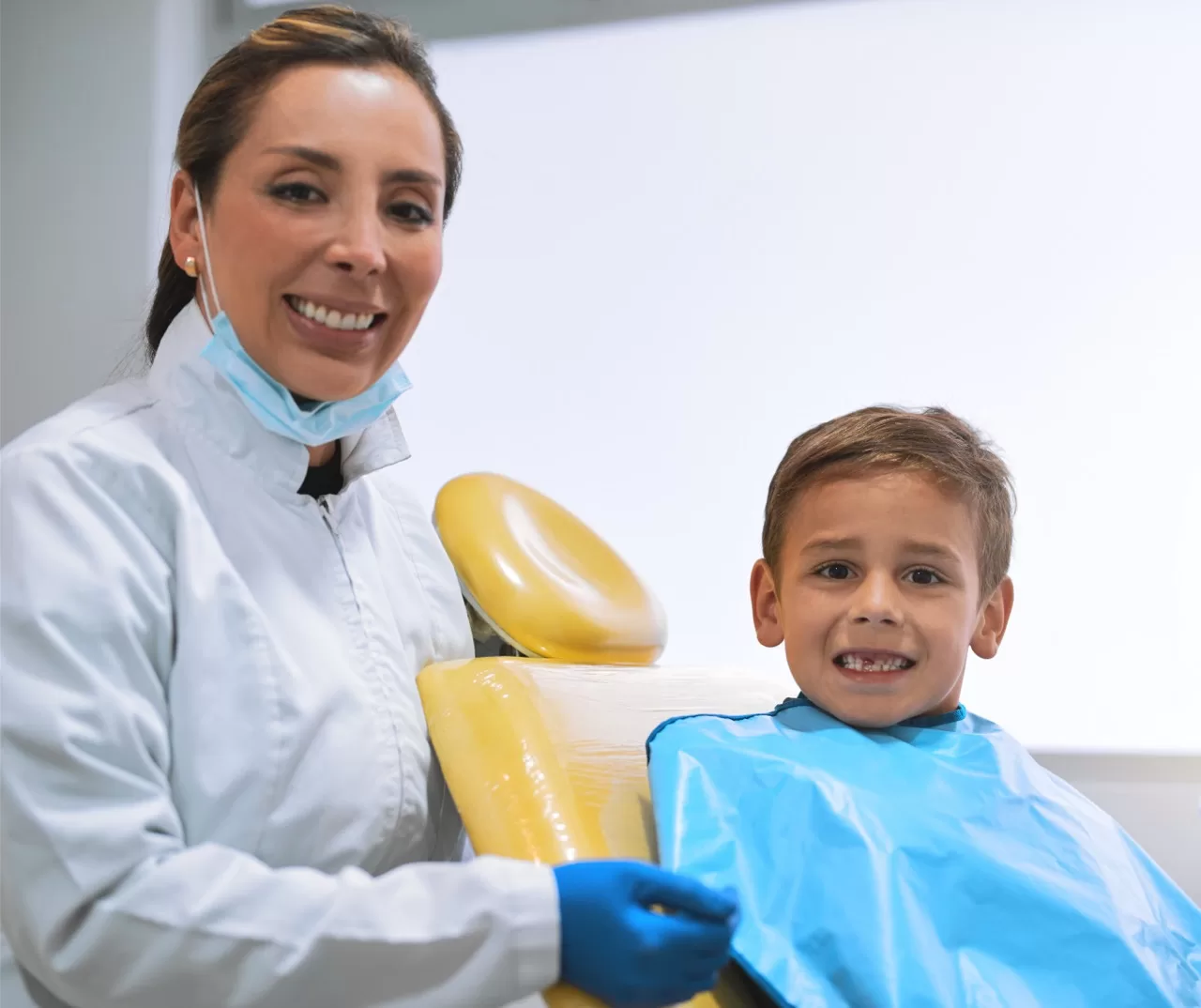 Pediatric dentist with child patient in dental chair