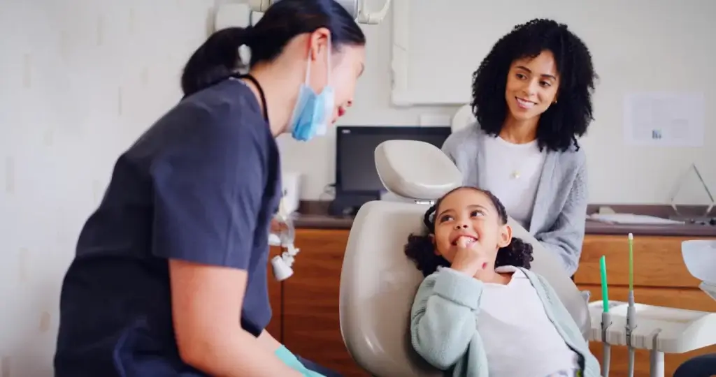 Pediatric dentist discussing dental care with a parent and child